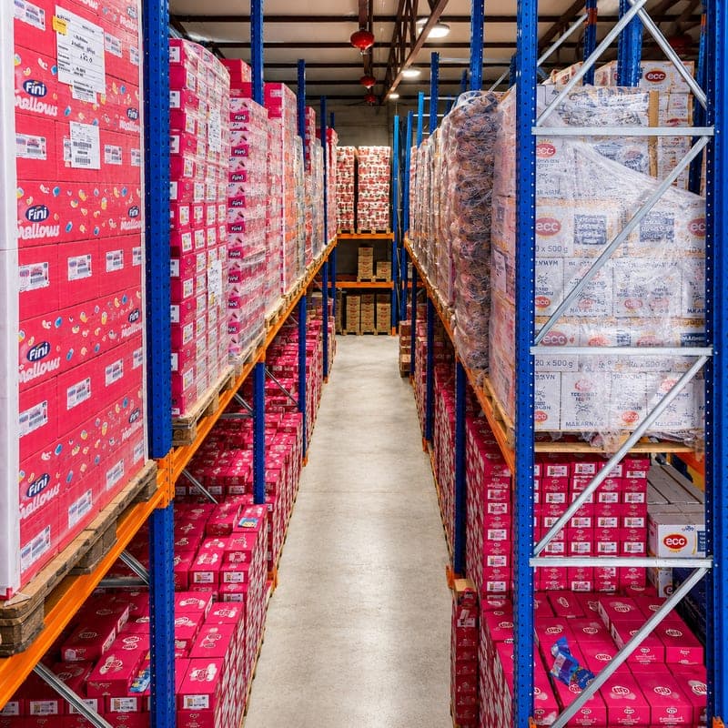 Palletised food and confectionery products along a warehouse aisle