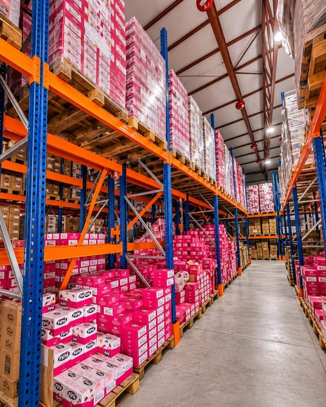 Product pallets stacked on high racking along a warehouse aisle